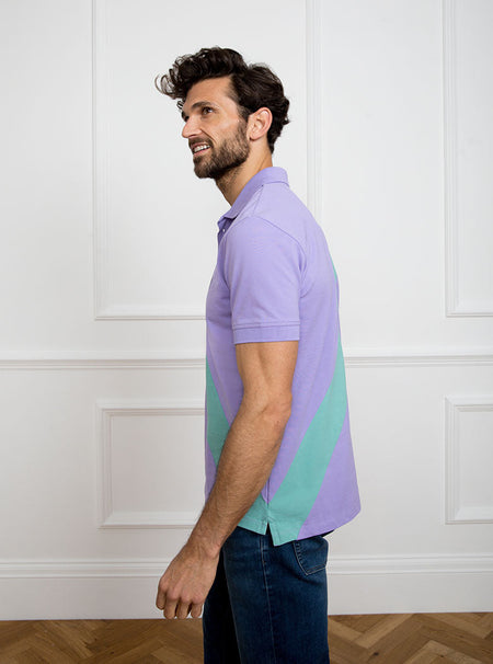 Man wearing lilac 100% cotton polo shirt with avocado green sash detail and Newmarket 875 horse logo embroidered on the front.